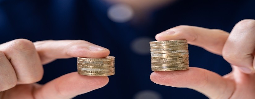 Man Holding Two Coin Stacks To Compare